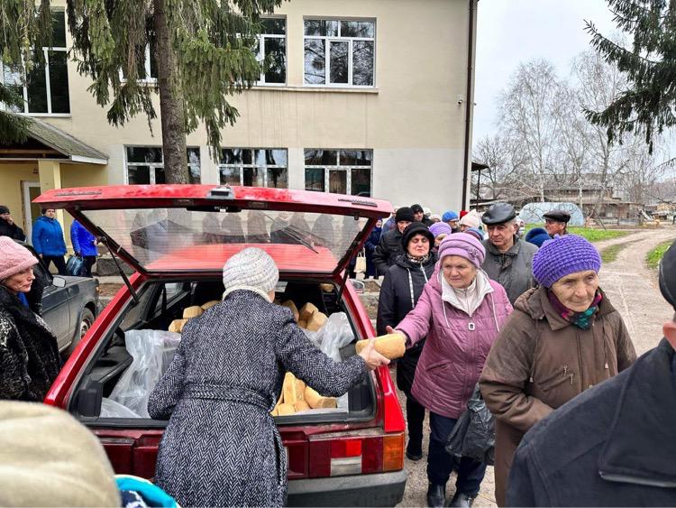 People receiving aid from the boot of a car