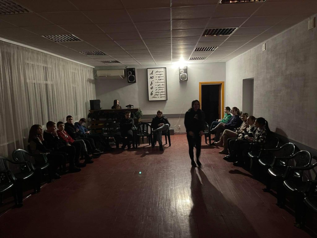 Youth gathered in a dimly lit room