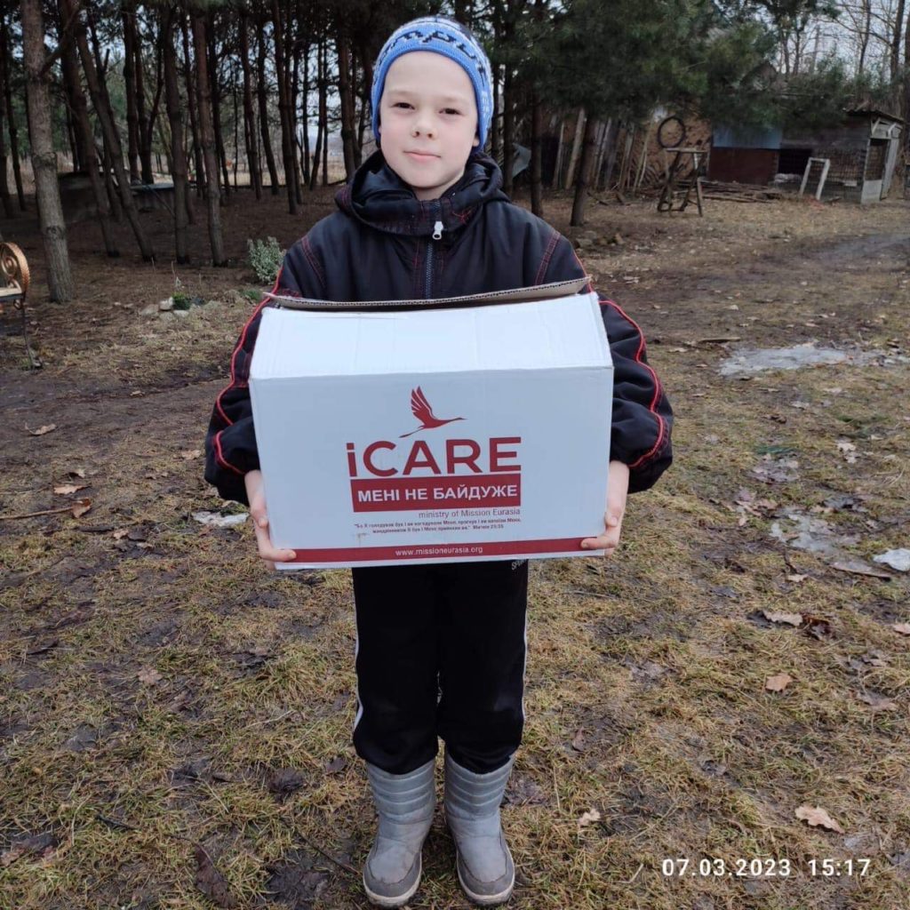 Young boy holding an iCare aid package