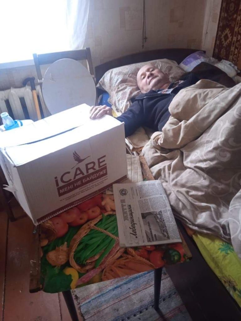 Man in a bed receiving an iCare aid package