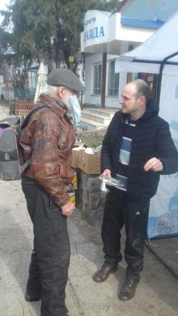 Man in Budylka receiving packs of seeds