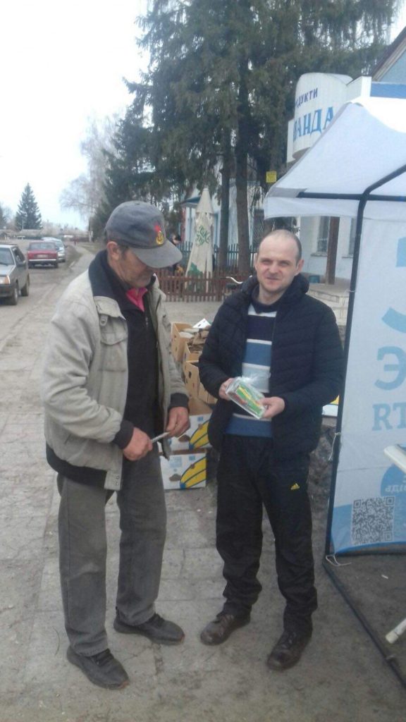 Men in Budylka receiving packs of seeds