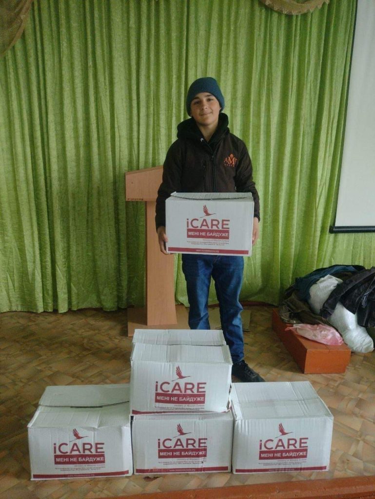 Teenage boy holding an iCare package in a hall