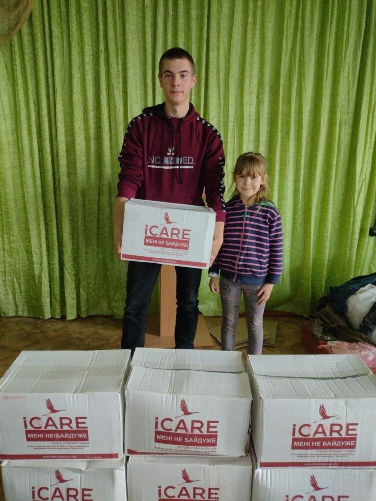 Man holding an iCare package with small girl next to him in a hall