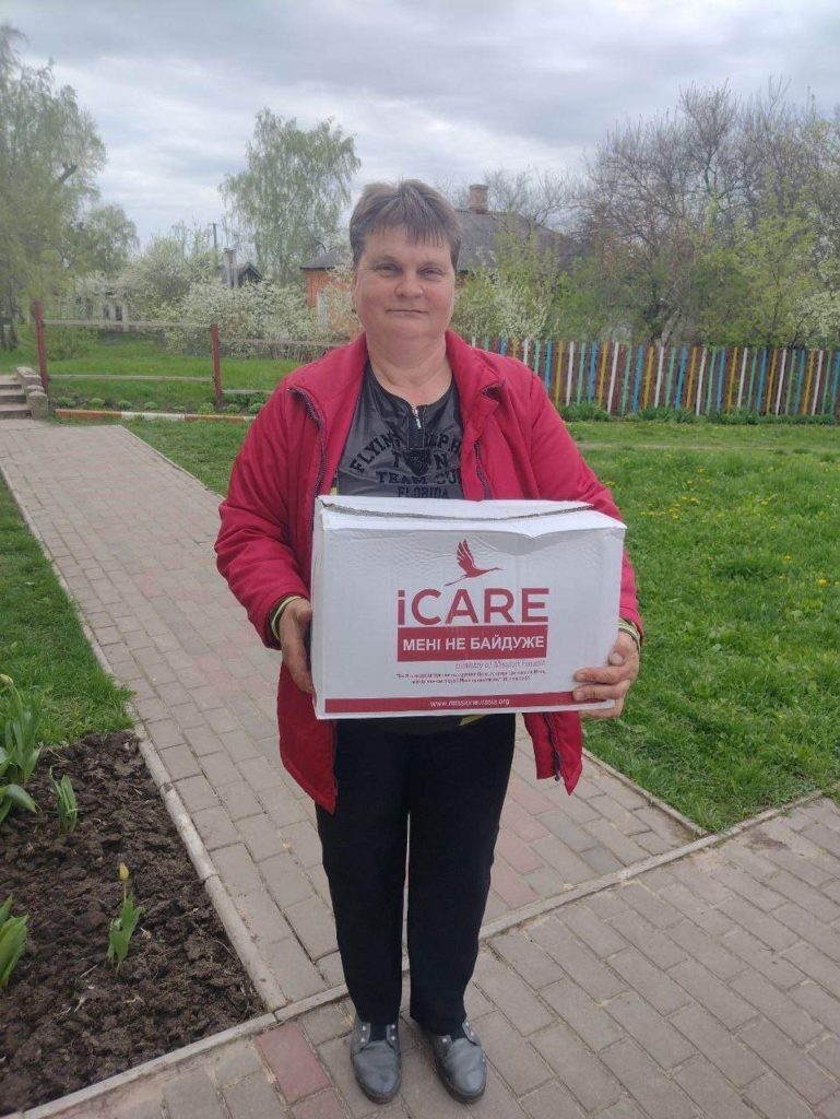 Woman holding an iCare package in a garden