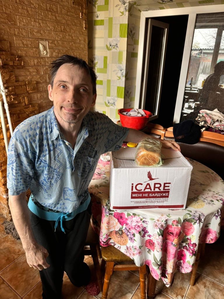 Man standing next to an iCare package on a table
