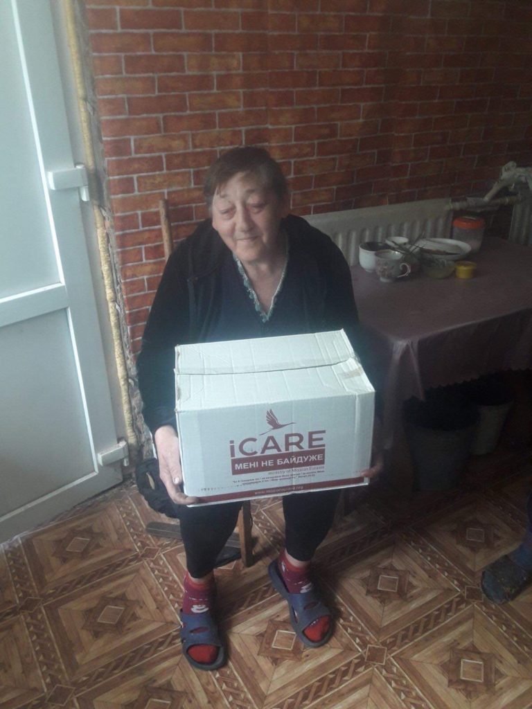 Lady sat down holding an iCare box