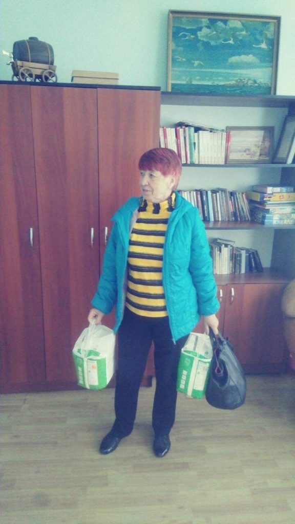 Lady collecting packs of nappies given as aid at the Centre