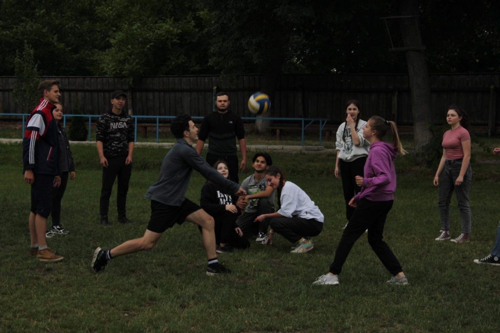 The youth knocking a volleyball around outside