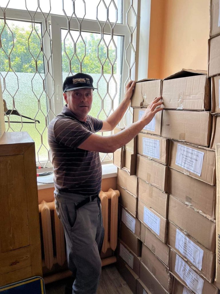 A man stacking donated boxes of the Jesus Storybook bibles that have been donated