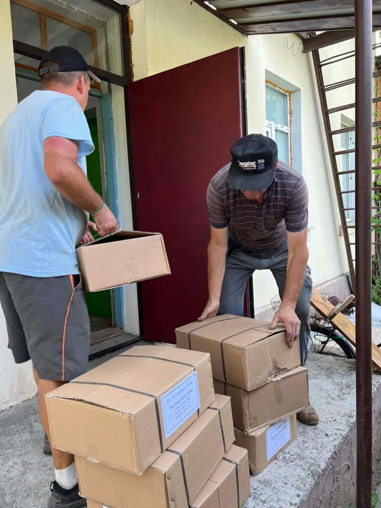 Two men unloading boxes of the Jesus Storybook bible