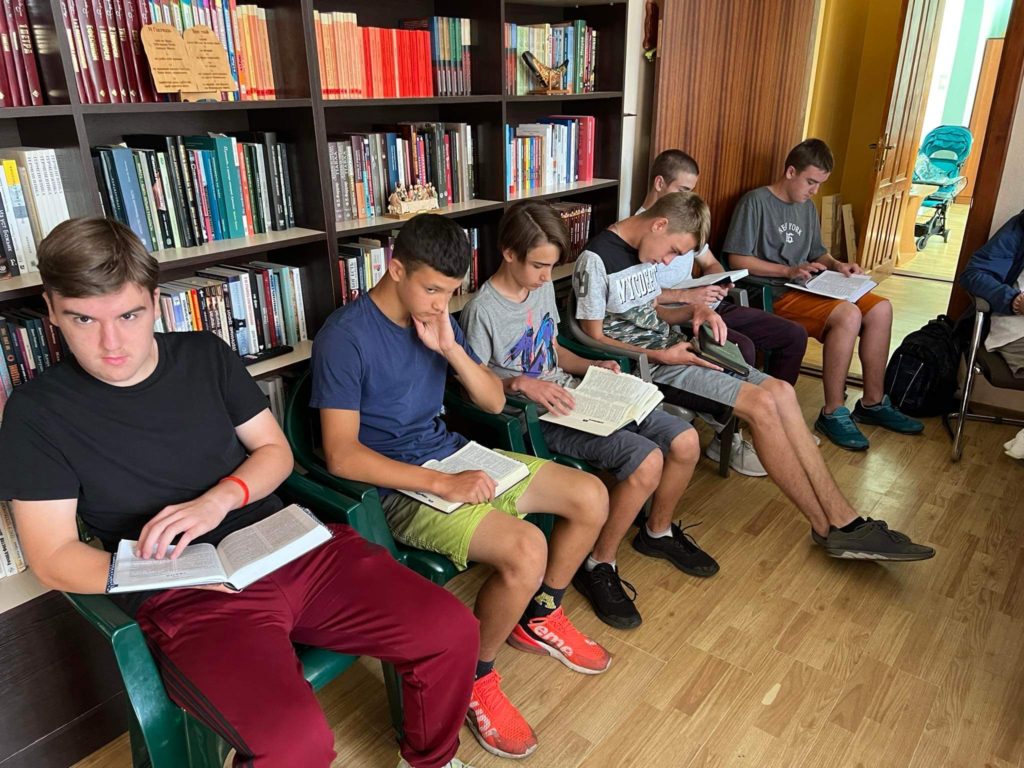 A group of teenage boys sitting reading their Bibles