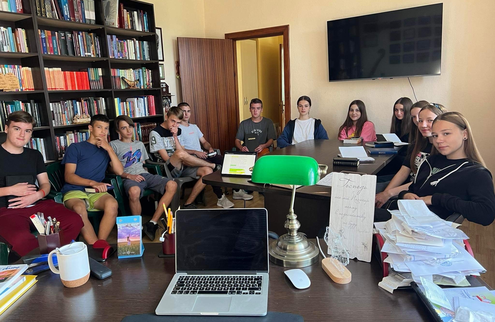 A group of teenagers sitting around a table in Bohdan's office as part of a Bible study