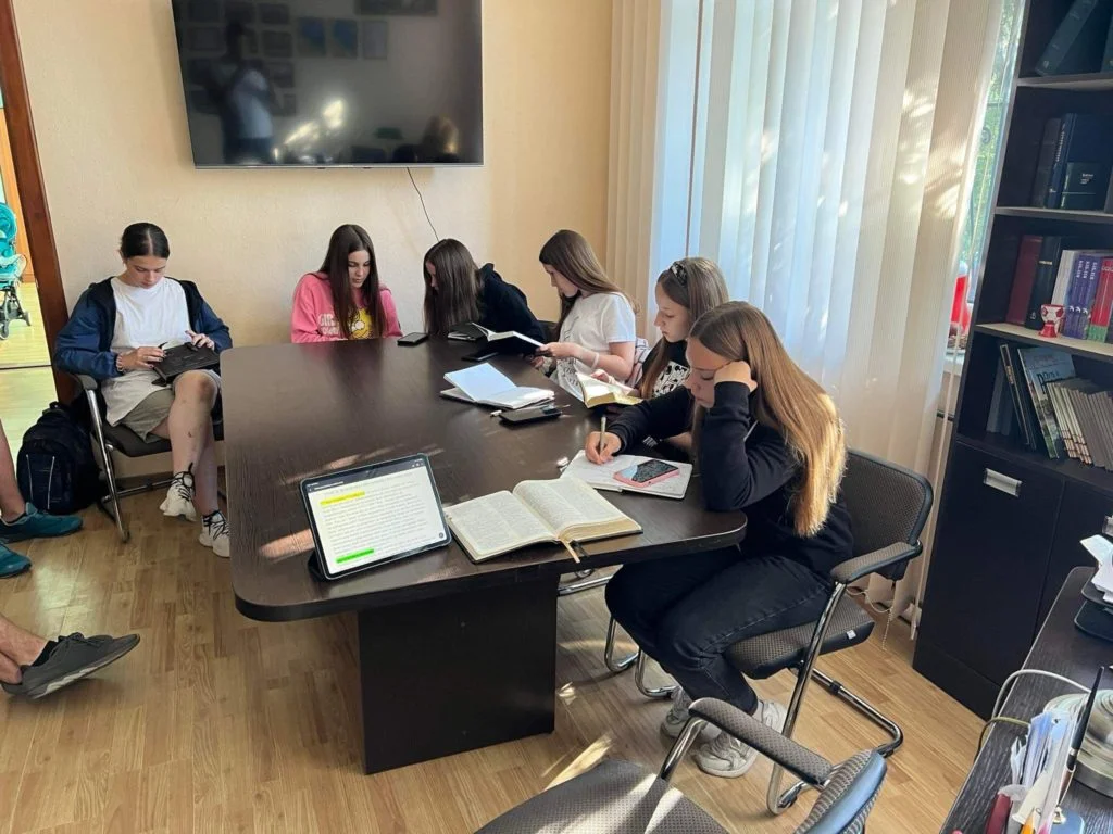 Teenage girls sitting around a table writing notes together