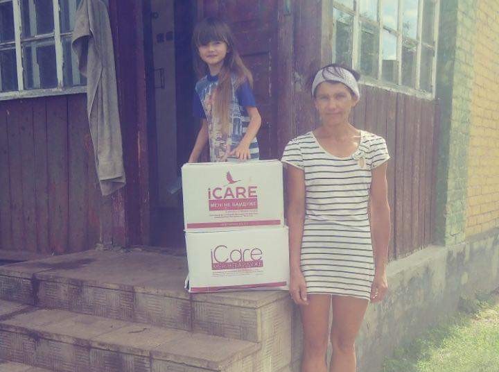Mother and daughter standing on steps with iCare packages