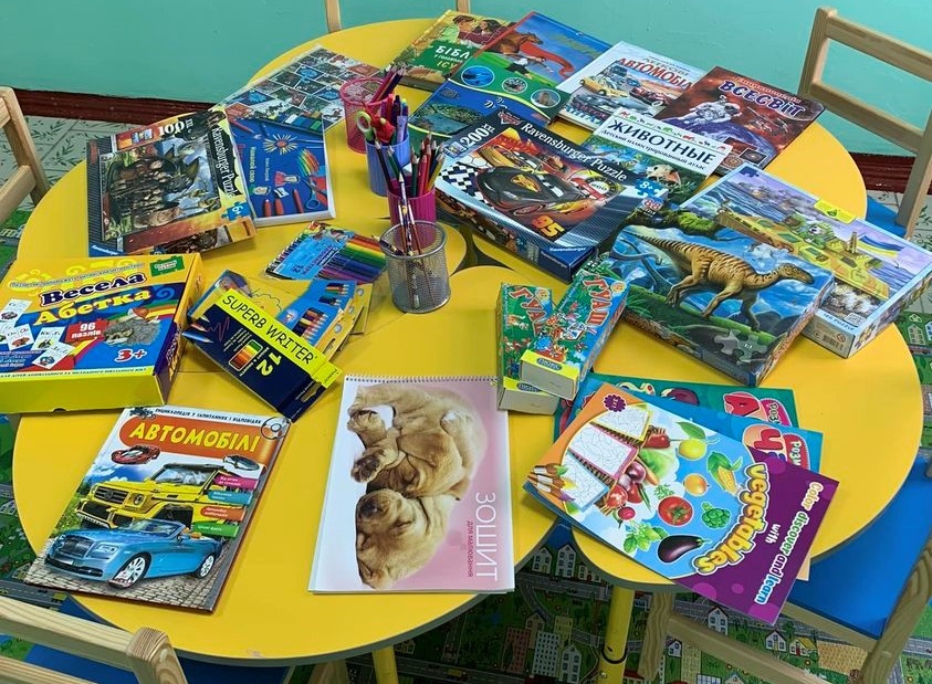Tables in the children's room at the local hospital covered with books, puzzles and colouring books