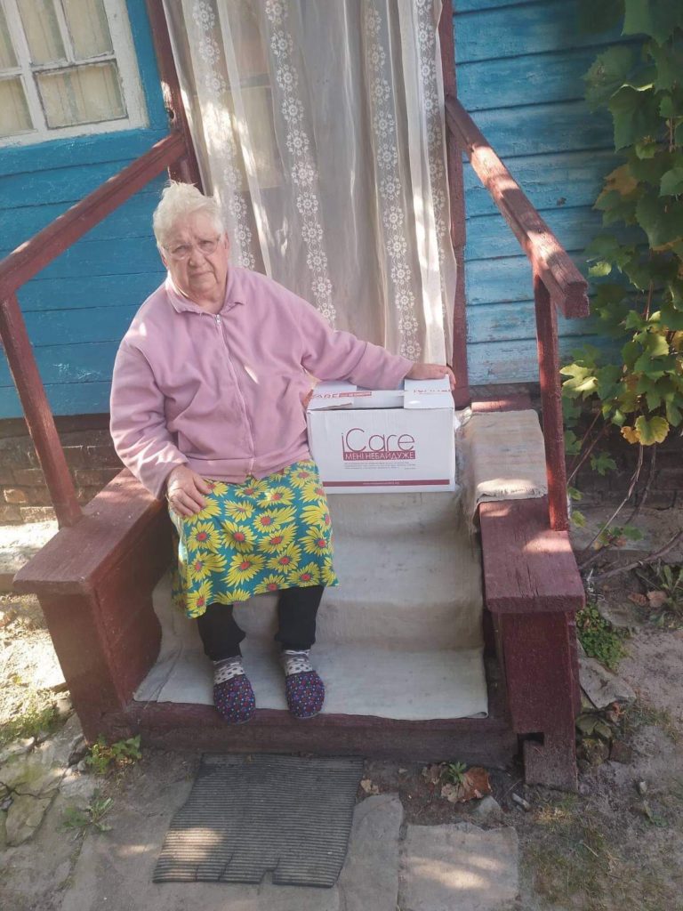 Lady sat on her front step sat next to an iCare package