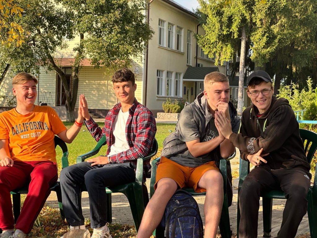 Teenage boys sitting in a group outside the Centre