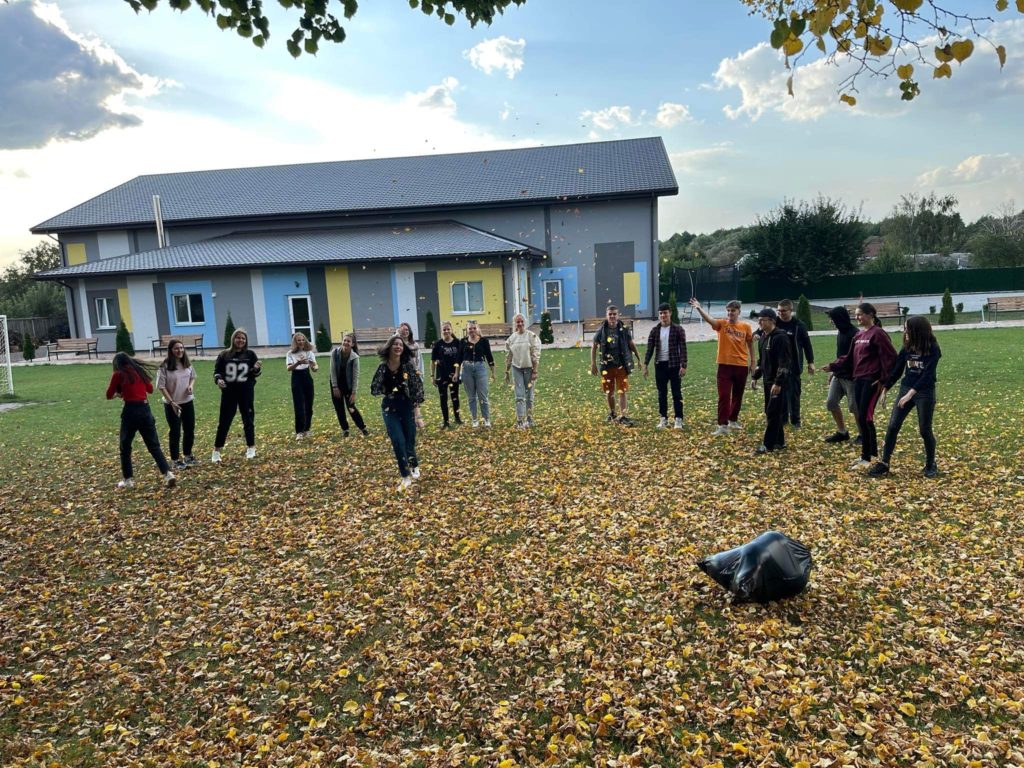 Youth group playing in the autumn leaves outside the Centre