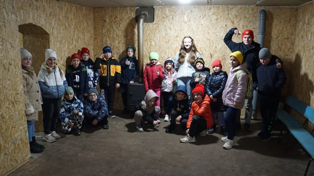 Children at the Autumn 2023 camp standing and sitting in the new bomb shelter