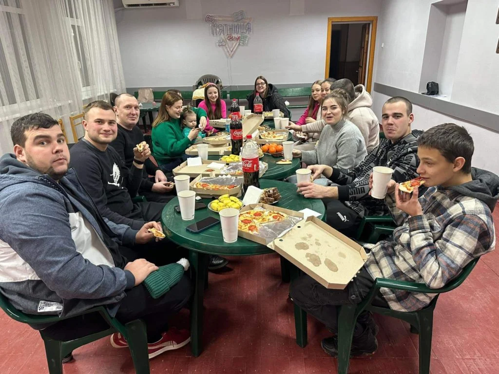 The team clebrating Bohdan's birthday sat round tables with pizza and drinks on them.