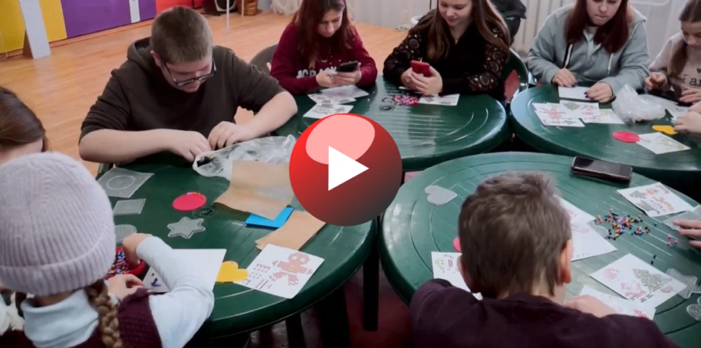 Children sitting round tables doing craft activities