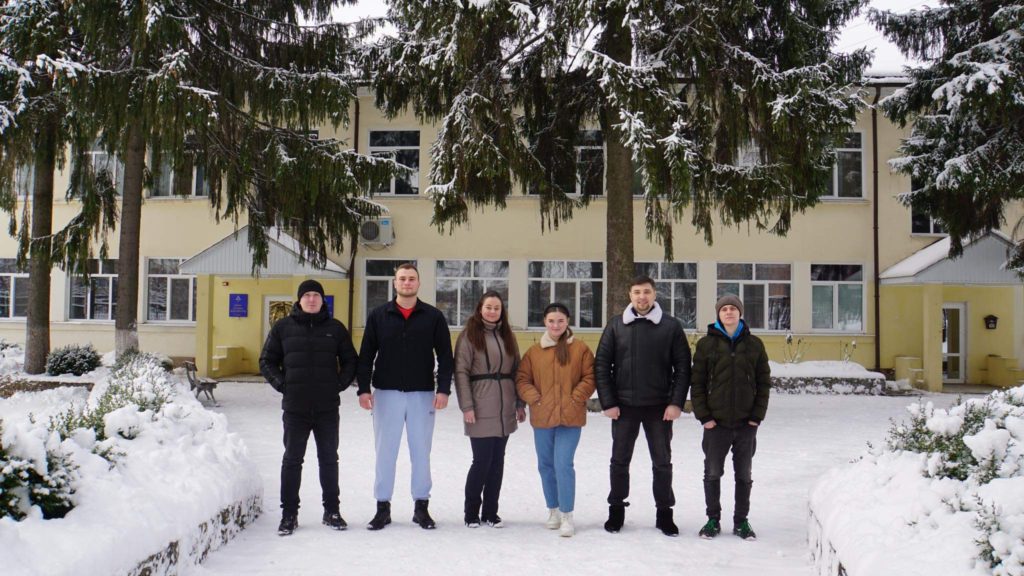 The team standing in front of the Centre building in the snow