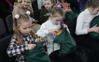 Children opening the bags containing presents at the Summer Camp