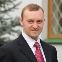 Eduard Borysov standing in a suit posing for the camera