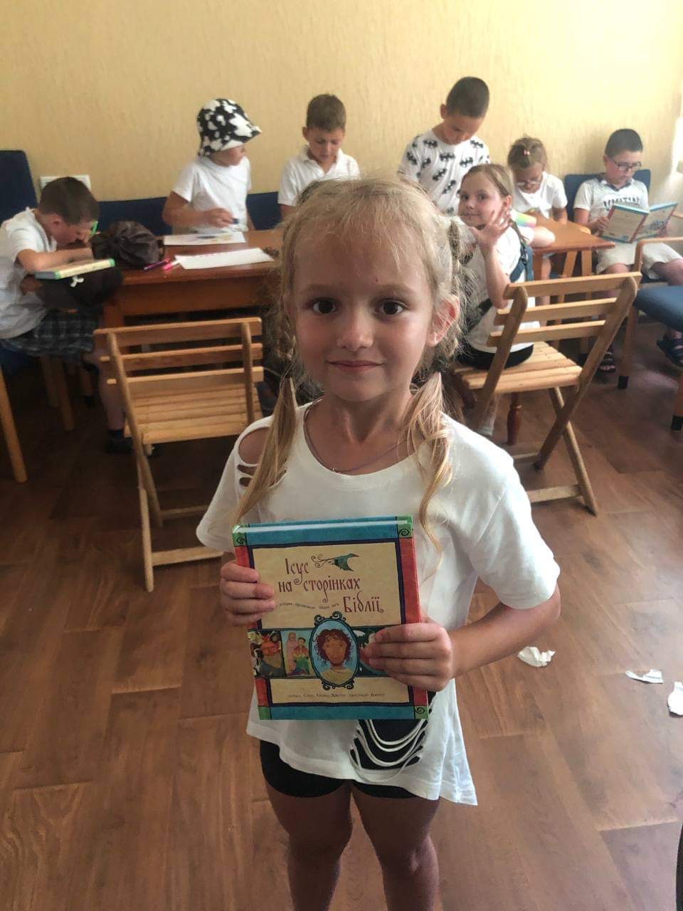 Young girl holding a copy of the Jesus Storybook Bible that she has been given
