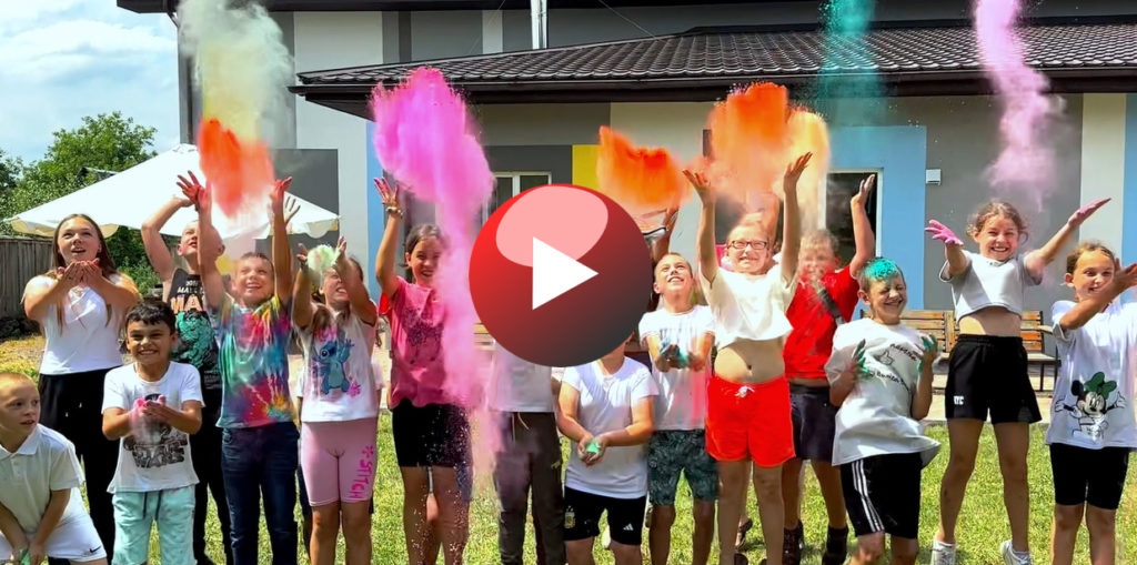 Children throwing coloured powder in the air at the Summer Camp 2024