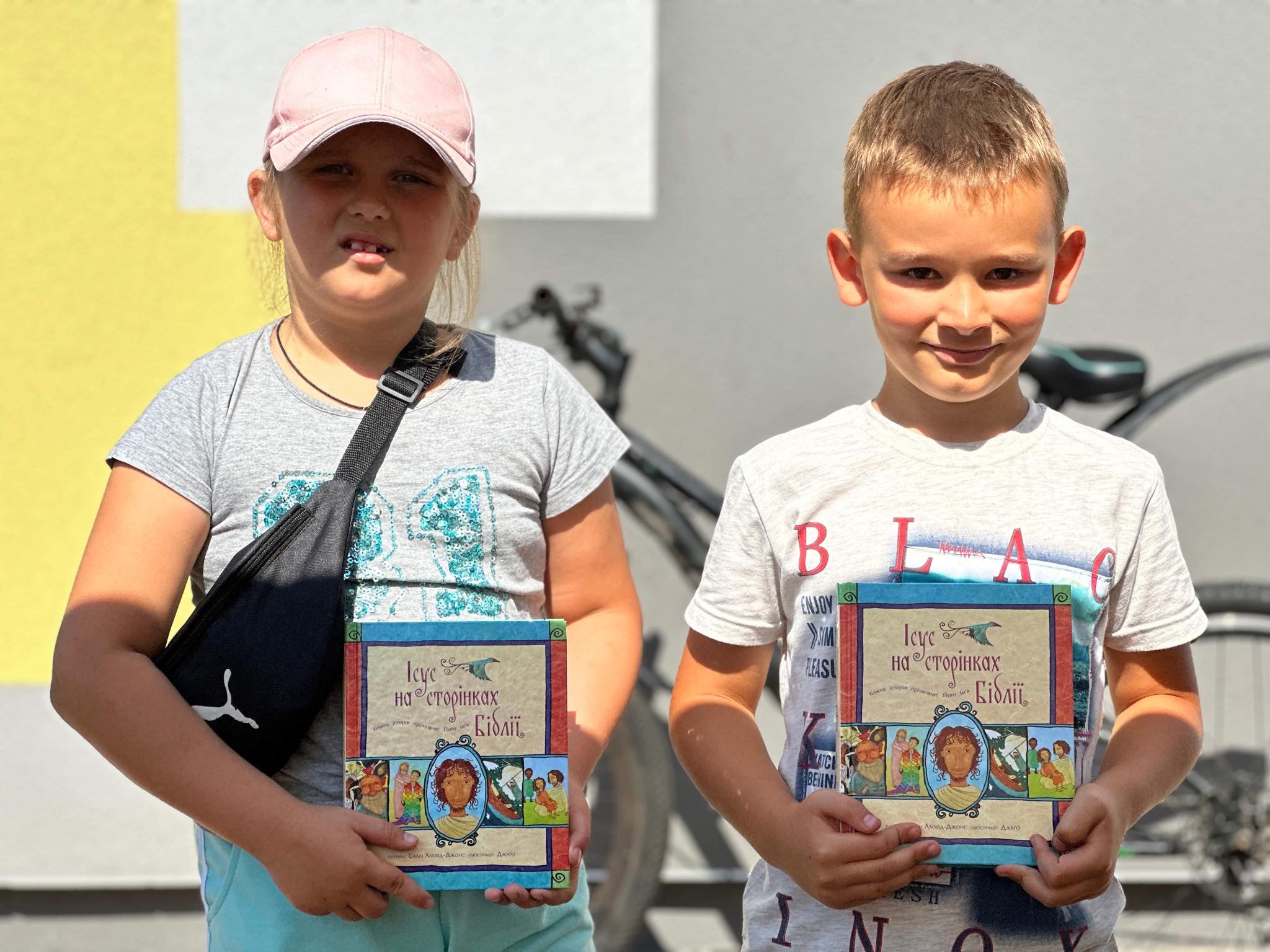 A young boy and a girl wolding copies of the Jesus Storybook Bible that they have been given
