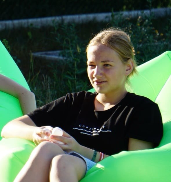 A girl called Margerite relaxing in an inflatable chair during the camp