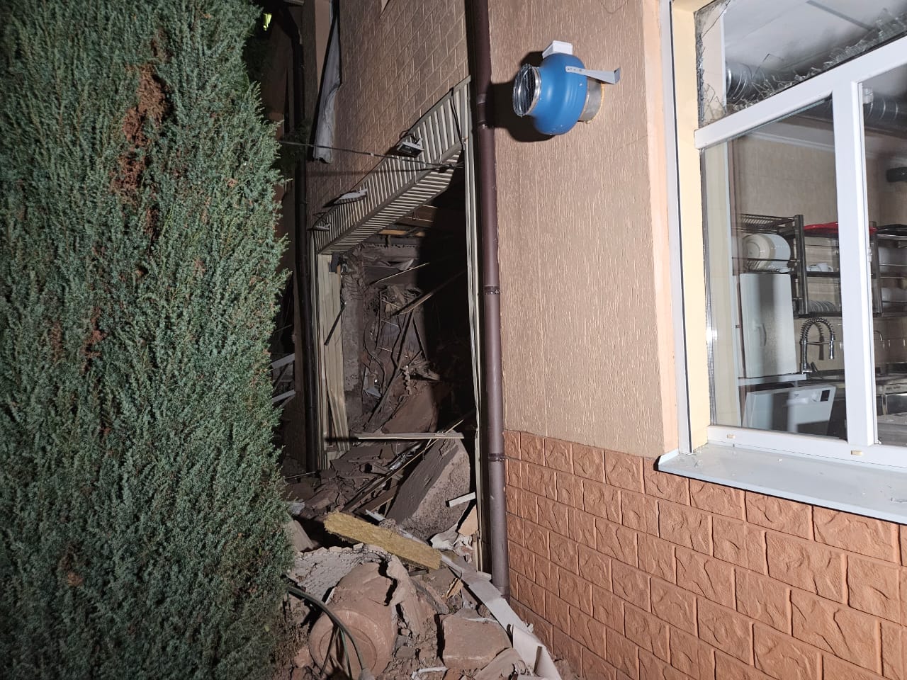 Aftermath of missile damage at Larissa's orphanage with damage to the ground floor and a broken window