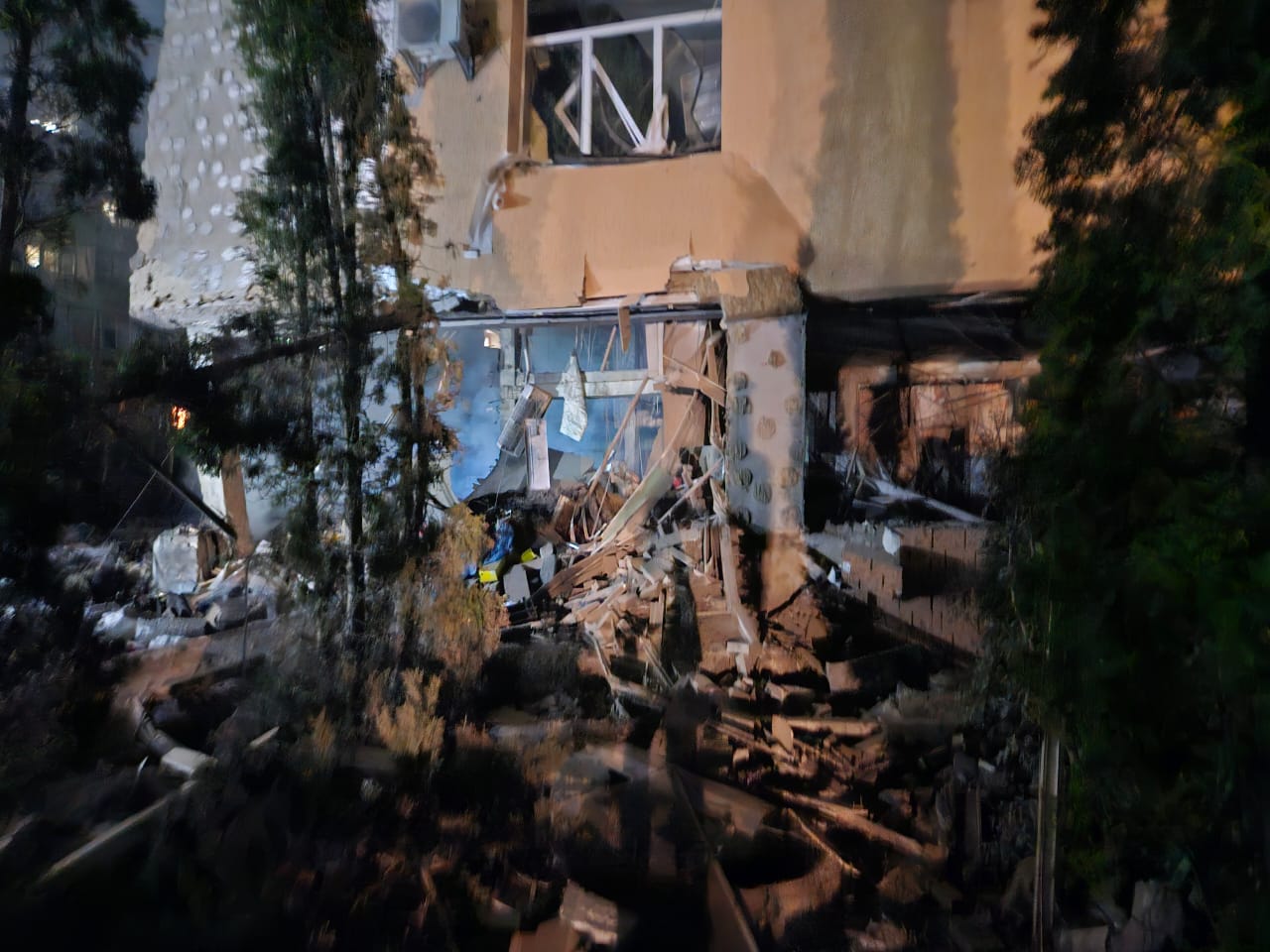 Aftermath of missile damage at Larissa's orphanage with broken windows and walls blown out on the ground floor.