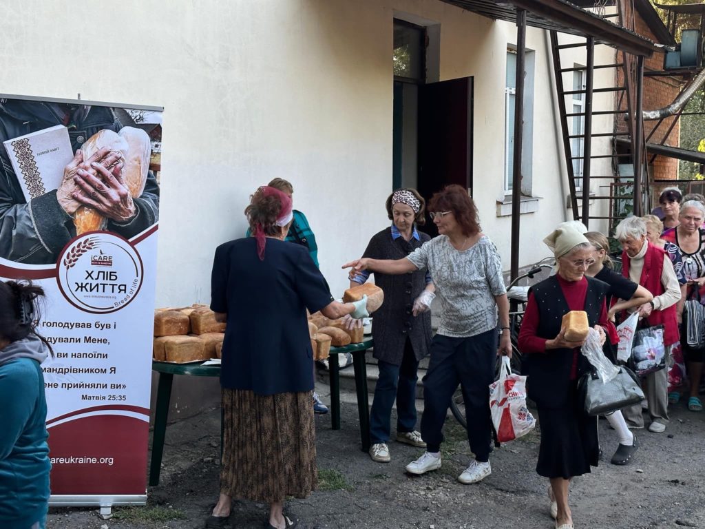 A queue of people at the bread donation table