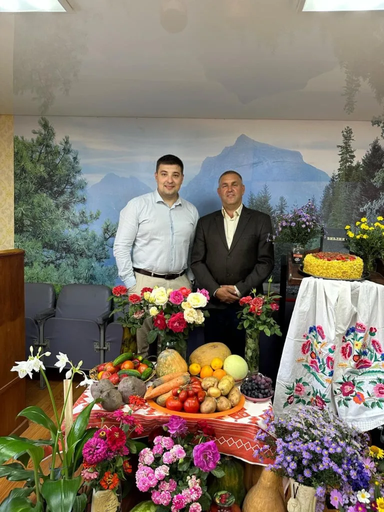 Bohdan and Pastor Andrew standing behind a display of Harvest Festival produce