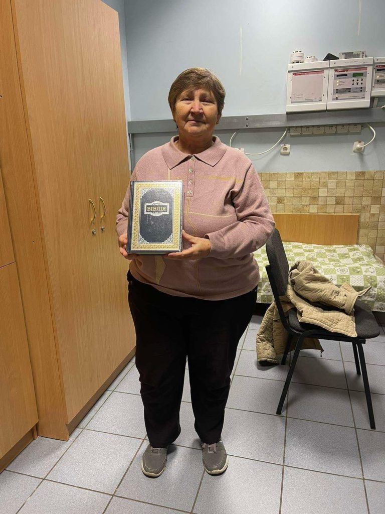 A lady standing in a bedroom holding a donated Bible