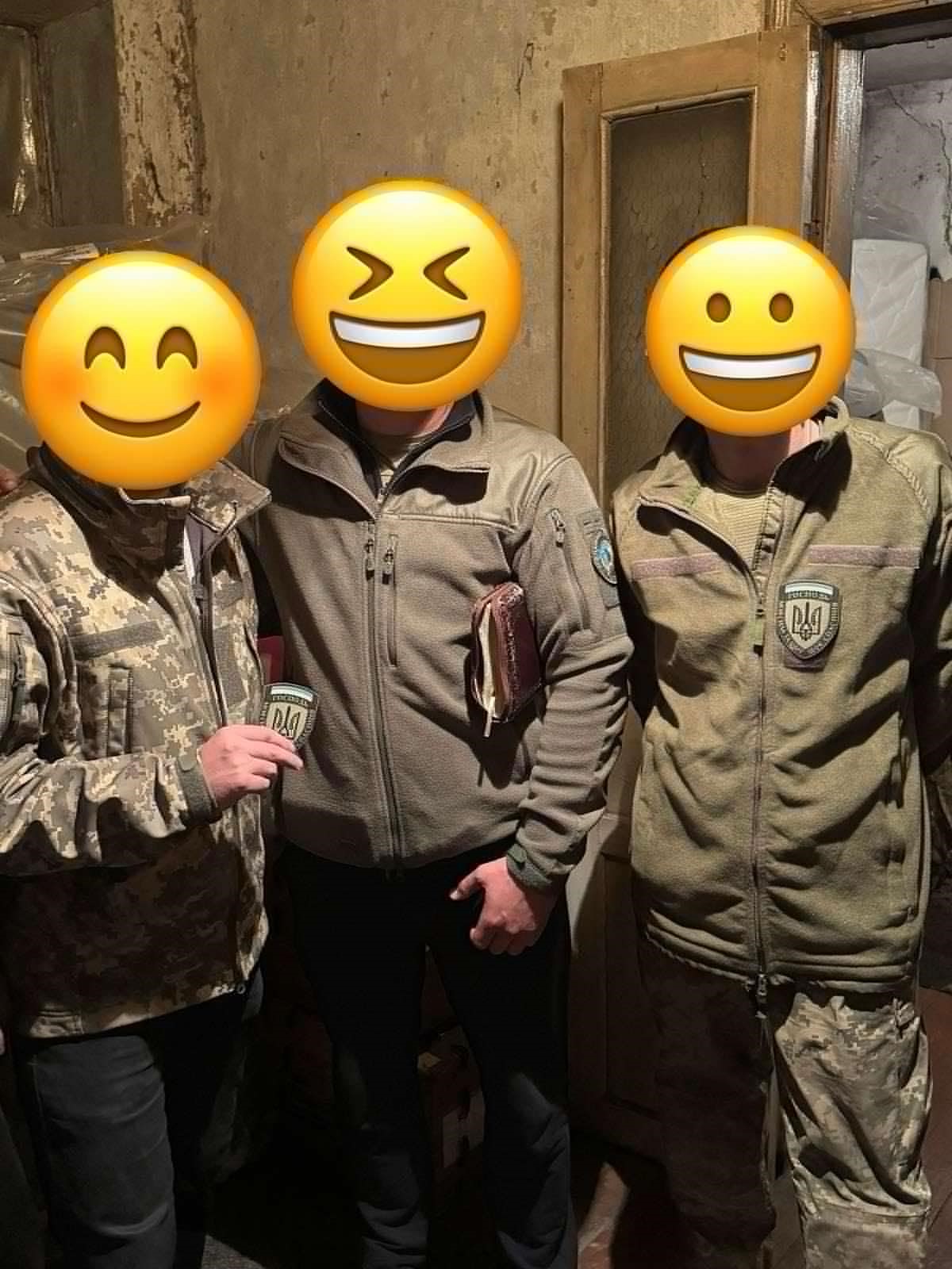 Three soldiers posing for the photo showing the new badges sewn onto their uniforms