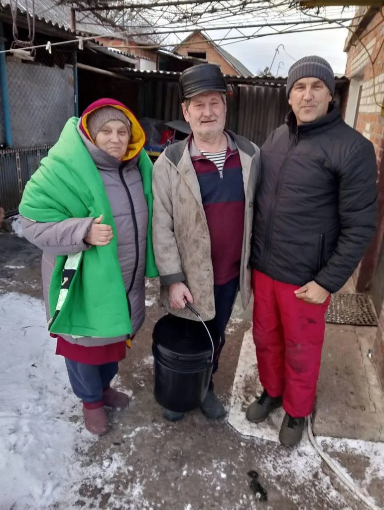 Pastor Andrew standing next to an older man and lady outside dressed in thick winter coats