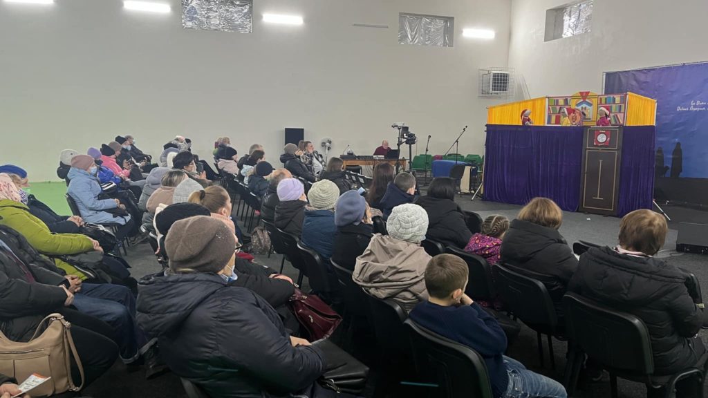 Refugees sat in the Centre watching the puppet show