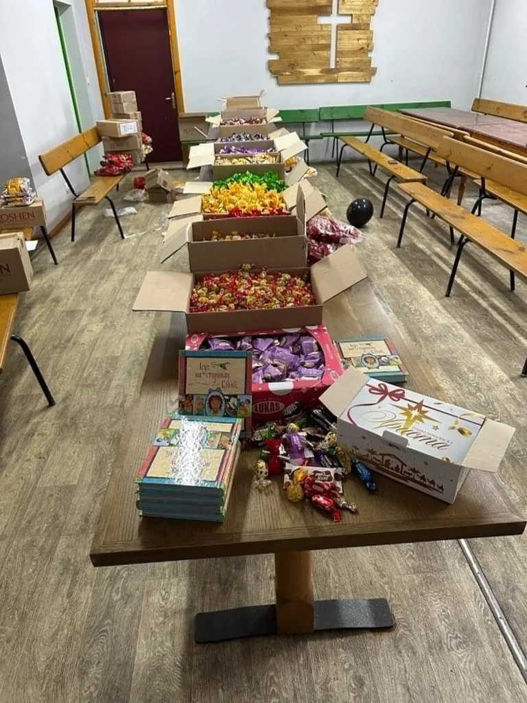 Boxes of sweets and Jesus Storybook Bibles laid out on a long row of tables