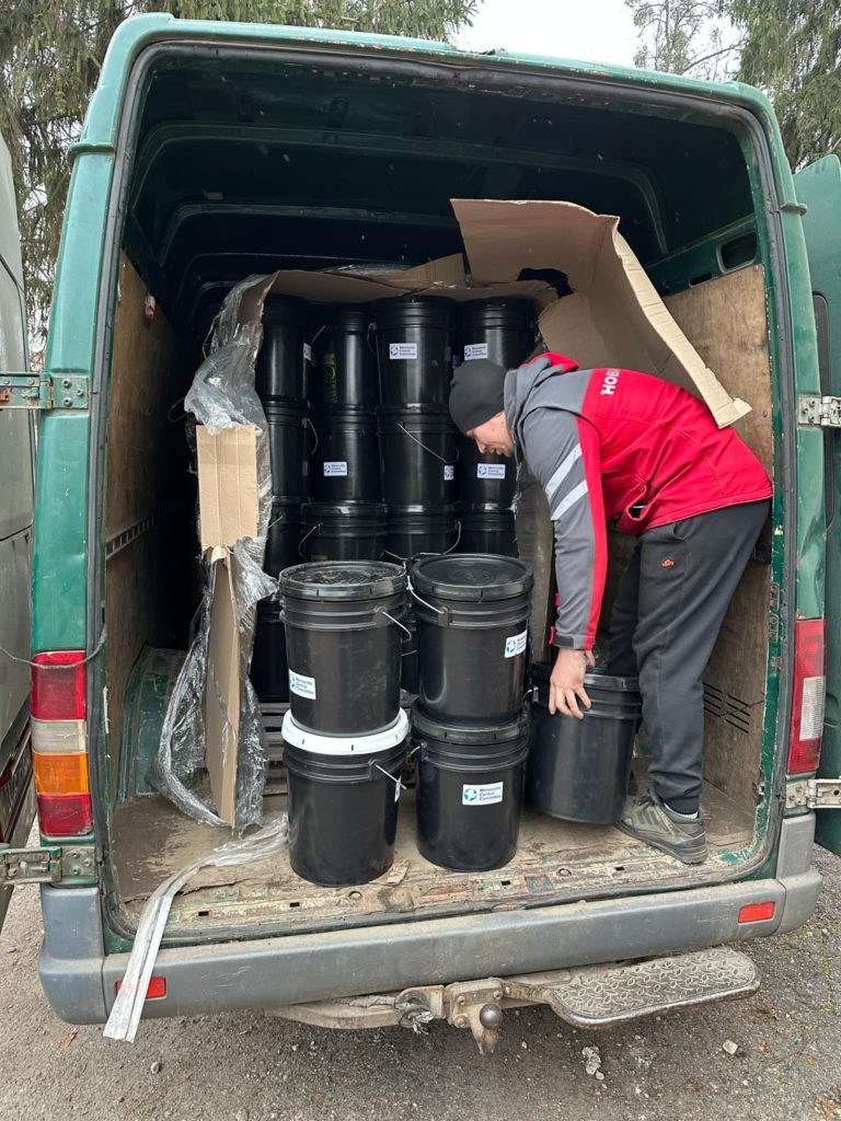 A pallet of hygiene buckets being broken down in the back of a van to be unloaded