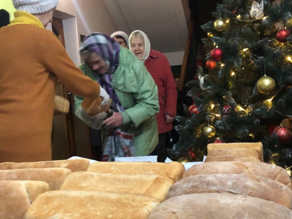 Ladies lined up in the Centre collecting loaves of bread