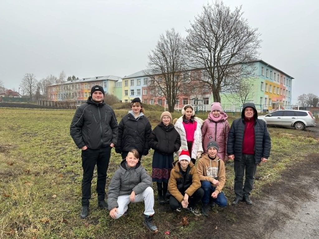 Bohdan and the team posing for a photo outside the school in Mykolaivka