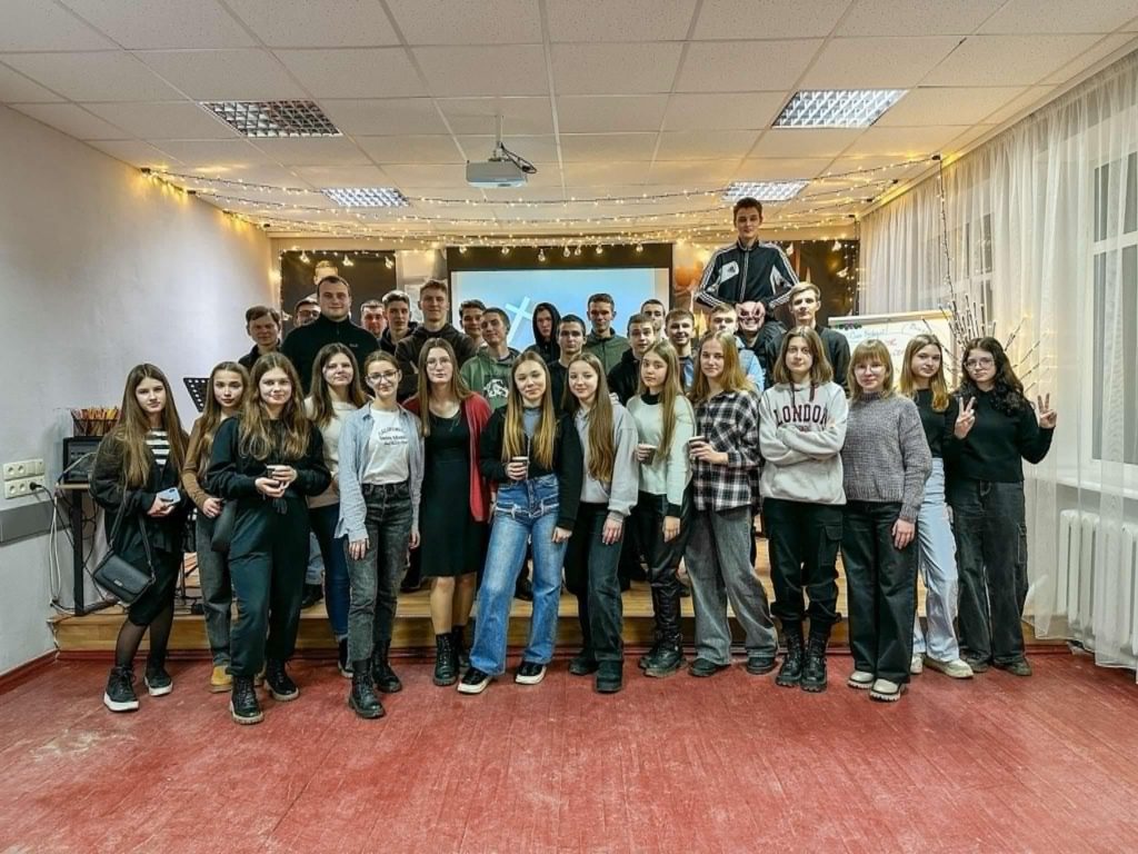 33 of the youth standing on the stage in the Centre posing for the photo