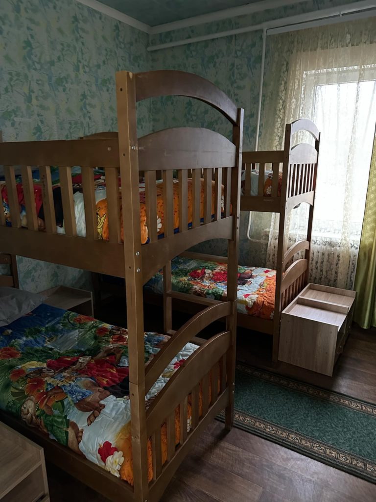 A small room with four bunk beds with the new bedding on them