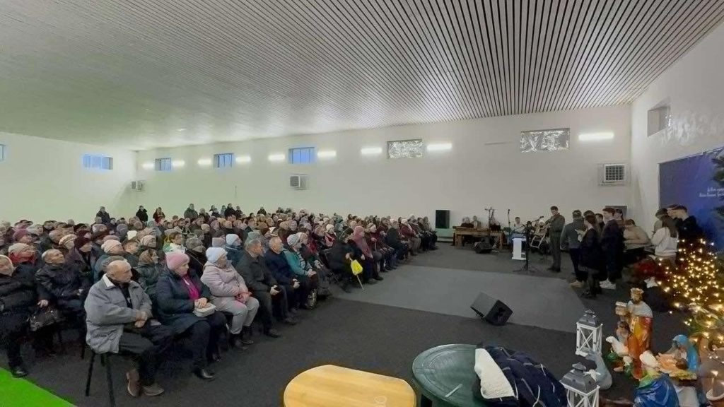 People sat in rows in the Centre during the service listening to the band play at the front.