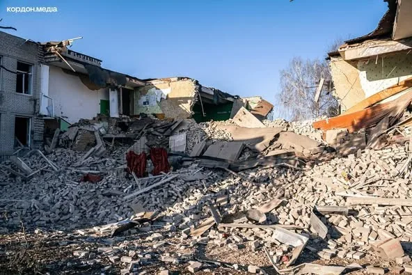 A huge pile of rubble where a house once stood with the remains of the neighbouring houses either side