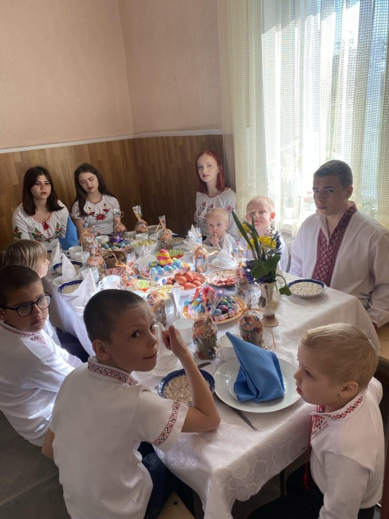 Children at Larisa's orphanage sat around a table enjoying an Easter meal